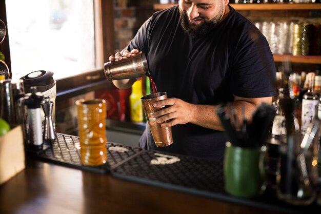 Gros plan sur le barman créant une délicieuse boisson