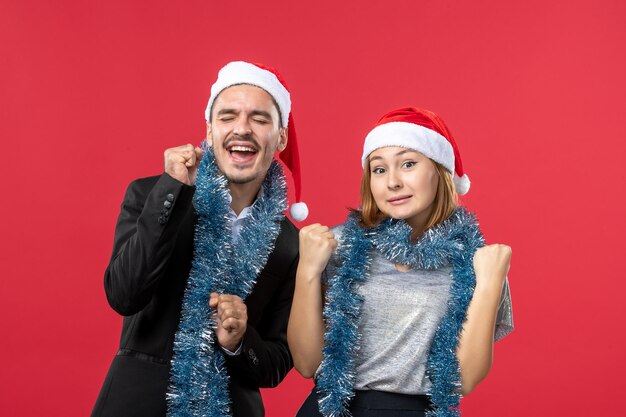 Gros plan sur un beau jeune couple portant des chapeaux de père Noël isolés