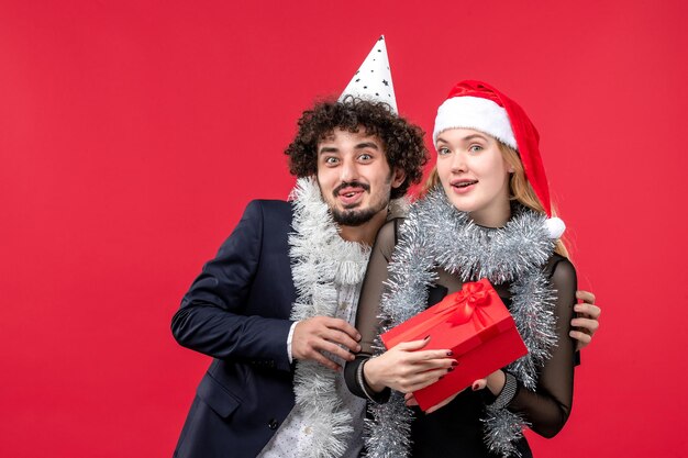 Gros plan sur un beau jeune couple portant des chapeaux de père Noël isolés