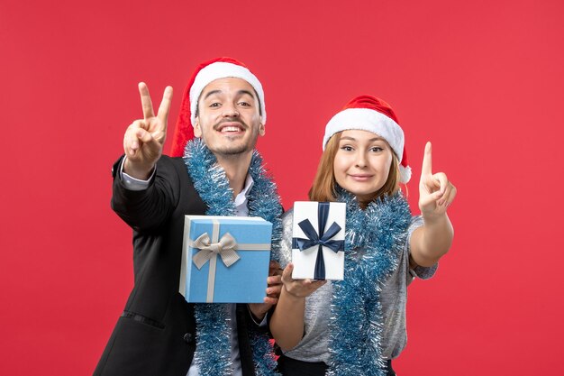 Gros plan sur un beau jeune couple portant des chapeaux de père Noël isolés