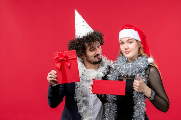 Gros plan sur un beau jeune couple portant des chapeaux de père Noël isolés