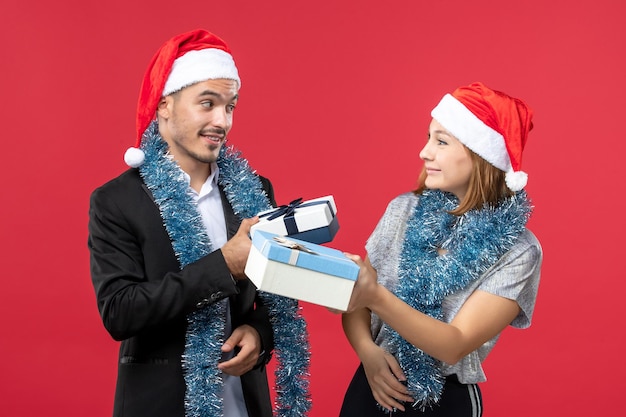 Gros plan sur un beau jeune couple portant des chapeaux de père Noël isolés