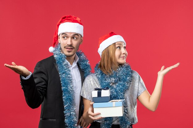 Gros plan sur un beau jeune couple portant des chapeaux de père Noël isolés