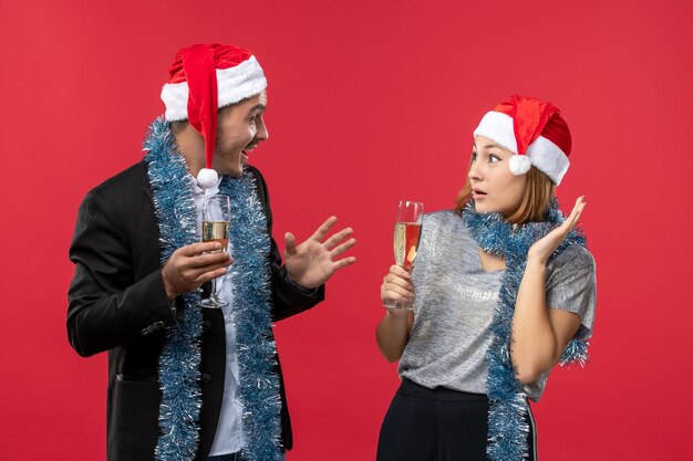 Gros plan sur un beau jeune couple portant des chapeaux de père Noël isolés