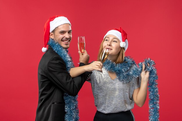 Gros plan sur un beau jeune couple portant des chapeaux de père Noël isolés