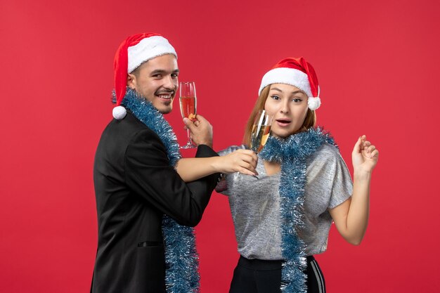 Gros plan sur un beau jeune couple portant des chapeaux de père Noël isolés