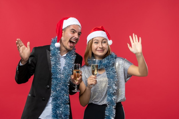 Gros plan sur un beau jeune couple portant des chapeaux de père Noël isolés