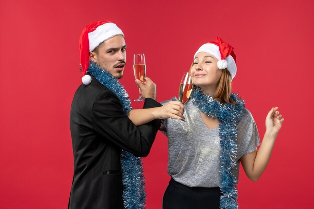 Gros plan sur un beau jeune couple portant des chapeaux de père Noël isolés