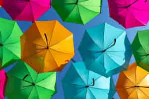 Photo gratuite gros plan d'un bel affichage de parapluie suspendu coloré contre un ciel bleu