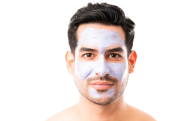 Gros plan d'un bel homme avec un masque facial sur fond blanc