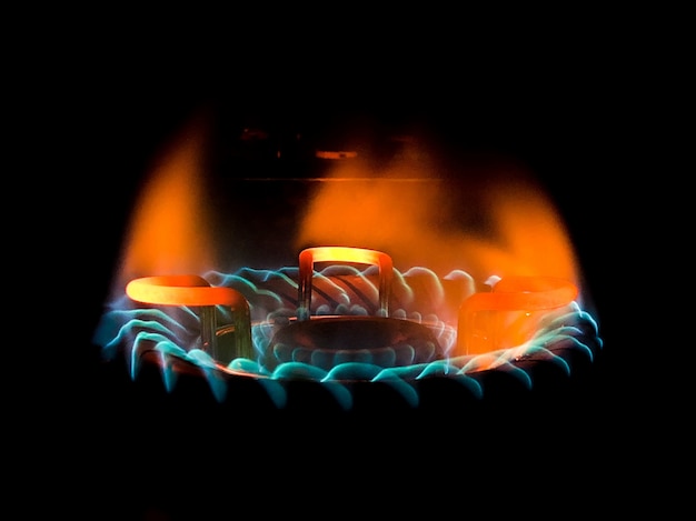 Gros plan d'une belle flamme bleu-vert dans une cuisinière à gaz