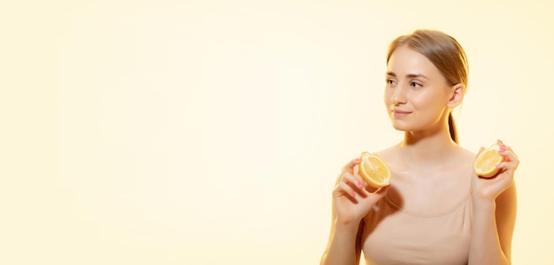 Gros plan sur une belle jeune femme avec du sérum versant, de l'huile sur du jaune