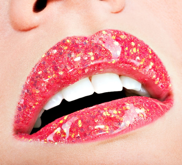 Gros plan de belles lèvres féminines avec rouge à lèvres brillant rouge brillant