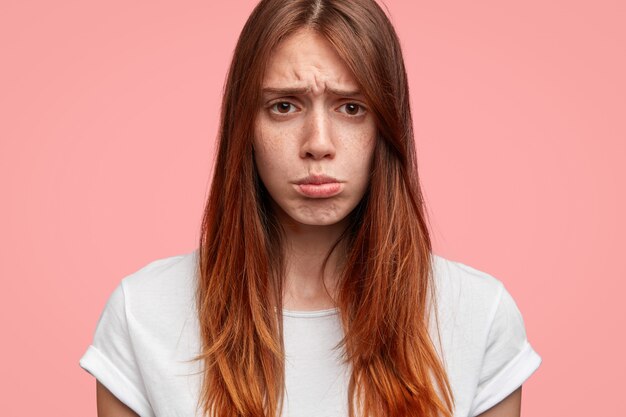 Gros plan de belles lèvres de mâles femelles maussades, a une expression triste, isolée sur fond rose.