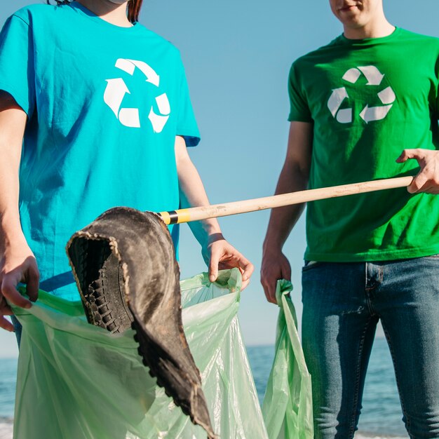 Gros plan de bénévoles ramassant des déchets sur la plage