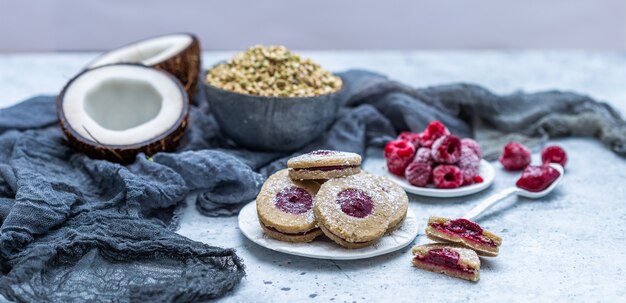 Gros plan de biscuits végétaliens crus avec noix de coco et framboises