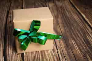 Photo gratuite gros plan d'une boîte-cadeau avec un ruban vert sur fond de bois