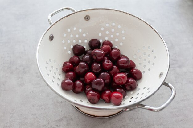 Gros plan d'un bol blanc avec beaucoup de cerises