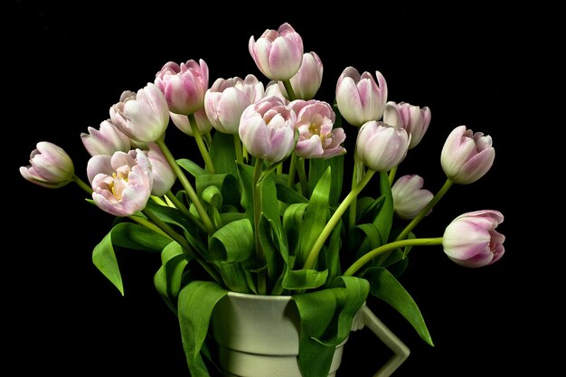 Gros plan d'un bouquet de tulipes roses dans un vase art déco
