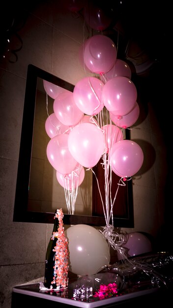 Gros plan, de, bouteille champagne, à, ballons roses, sur, bureau