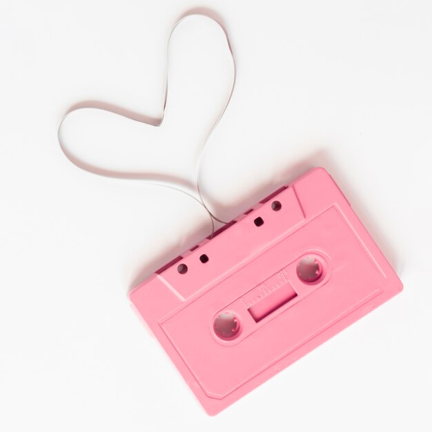 Gros plan d'une cassette rose sur fond blanc