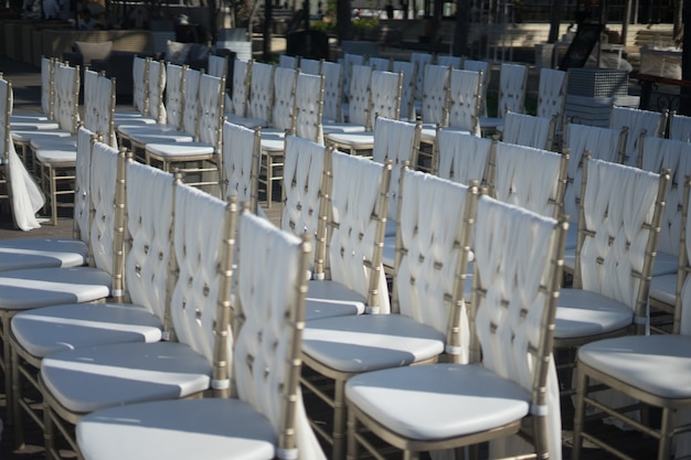 Gros plan de chaises blanches pour les invités d'une cérémonie de mariage