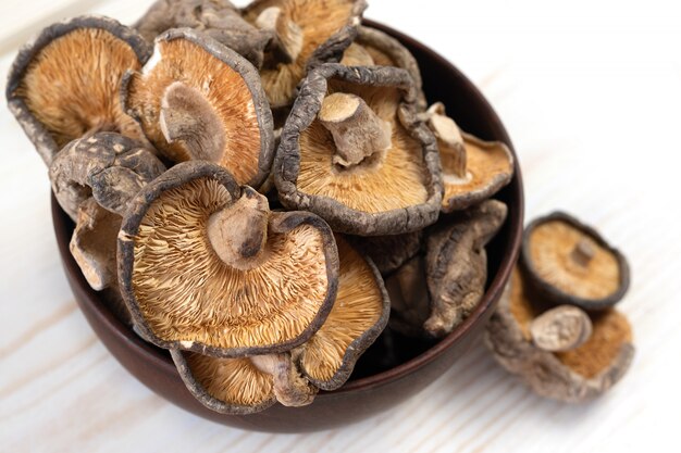 Gros plan de champignons shiitake séchés sur fond de bois