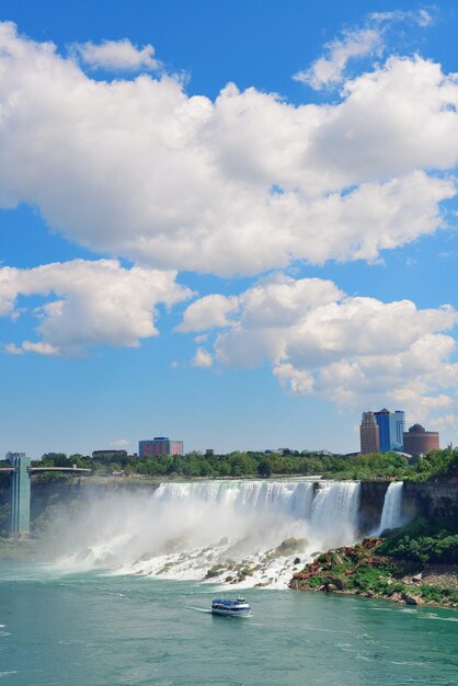 Gros plan des chutes du Niagara dans la journée sur la rivière avec des rochers et un bateau