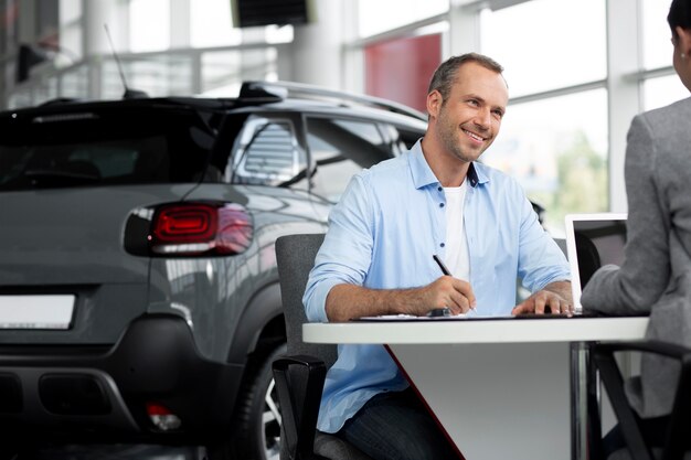 Gros plan sur un client heureux chez un concessionnaire automobile