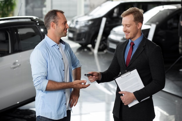 Gros plan sur le client avec un homme d'affaires chez un concessionnaire automobile