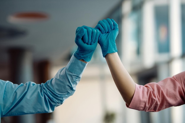 Gros plan sur des collègues qui se cognent le poing tout en portant des gants de protection