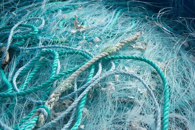 Gros plan sur des cordes bleues et des filets de pêche les uns sur les autres sous la lumière du soleil