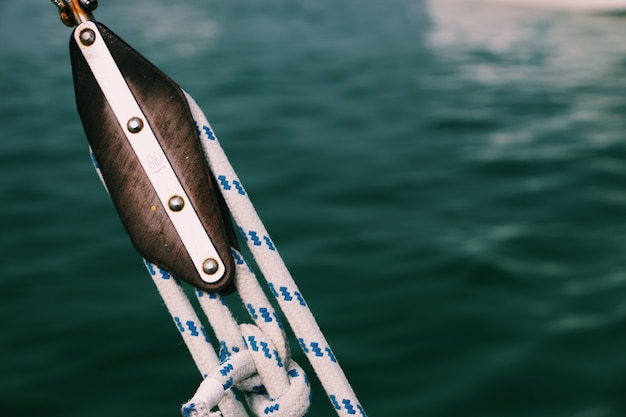 Gros plan de cordes serrées sur un bateau de pêche avec une mer floue