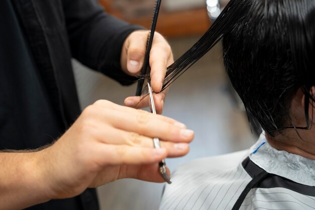 Gros plan sur la coupe des cheveux à la main avec des ciseaux