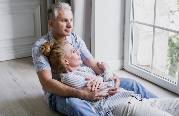 Gros plan, couple aîné, étreindre, sur, les, plancher