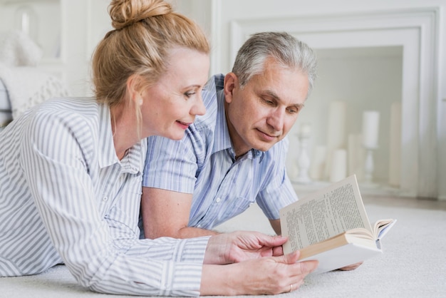 Gros plan, couple aîné, lecture livre