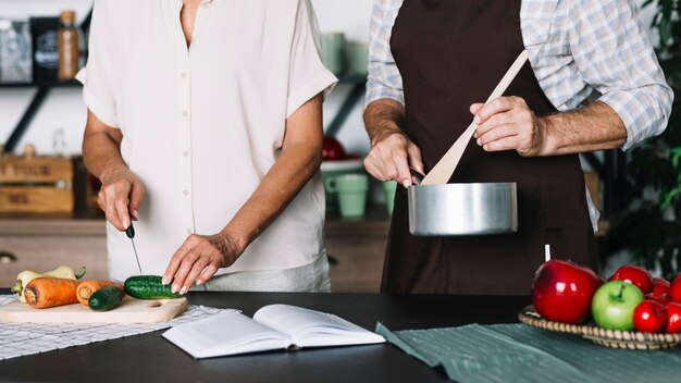 Gros plan, couple aîné, préparer nourriture dans cuisine