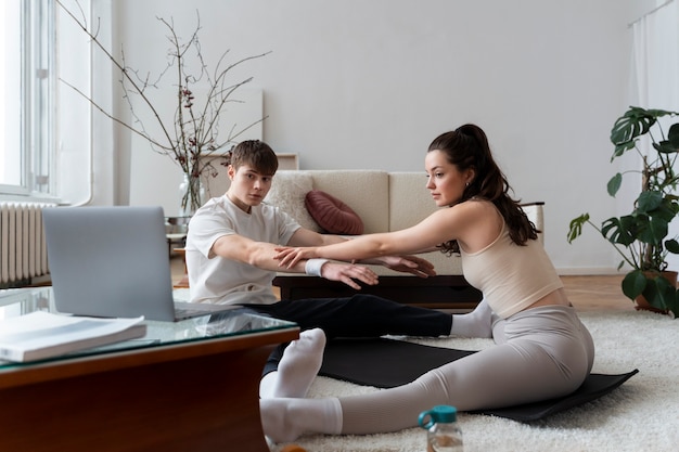 Gros plan sur un couple faisant de l'exercice après un instructeur en ligne