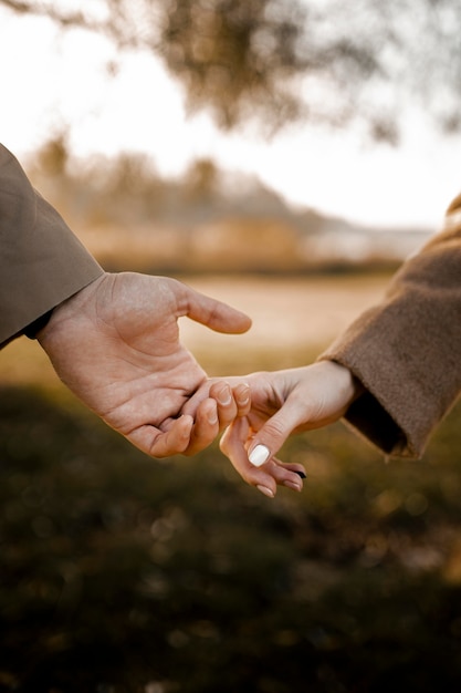 Gros plan couple main dans la main à l'extérieur