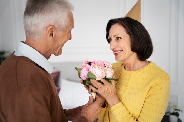 Gros plan couple de personnes âgées avec des fleurs