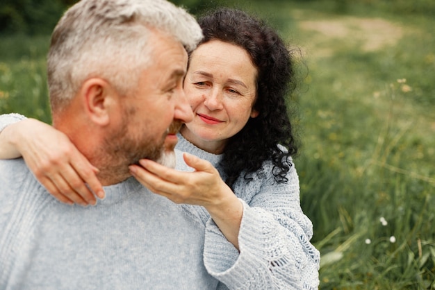 Gros plan sur un couple romantique assis dans un parc en automne et s'embrassant dans la journée