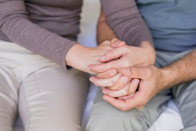 Gros plan, couples aînés, tenant mains