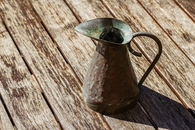 Gros plan d'une cruche vintage sur une surface en bois