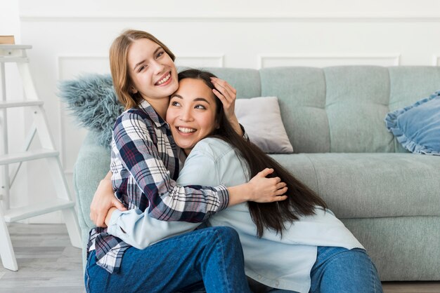 Gros plan des dames étreignant et souriant