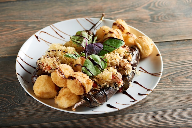 Gros plan de délicieuses boules de fromage frit servies avec aubergines et basilic sur une table en bois café restaurant repas dîner déjeuner faim appétit savoureux concept de nutrition.