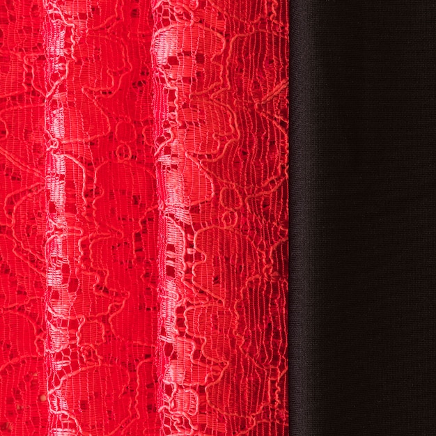 Gros plan de la dentelle rouge et fond de tissu noir