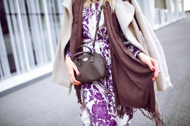 Photo gratuite gros plan des détails de mode, couleurs à la mode taupe, femme portant un manteau élégant, robe maxi à fleurs, sac à bandoulière, accessoires et bijoux à la mode, printemps automne, manucure bordeaux.