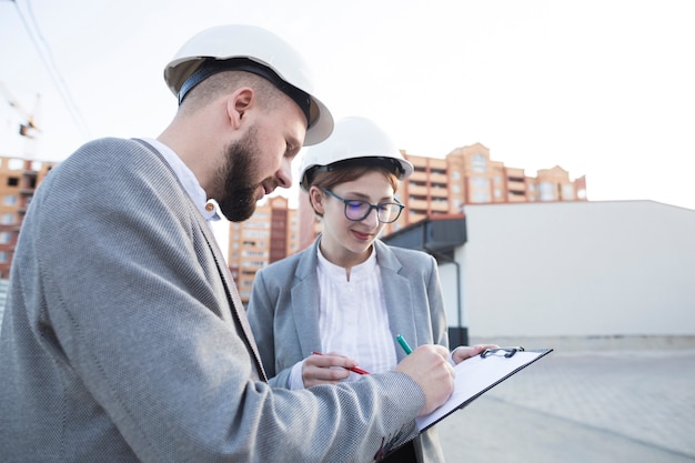 Gros plan, deux, architecte, travailler ensemble, sur, chantier construction