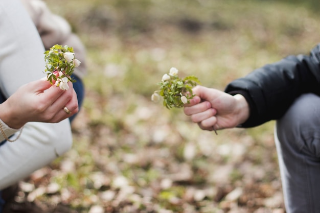 Gros plan de deux mains avec des fleurs