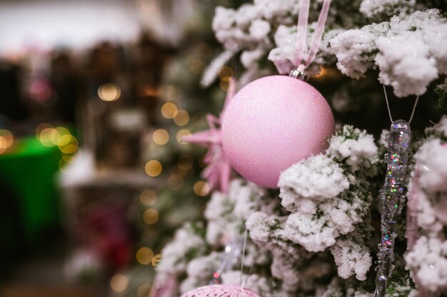 Gros plan de différents objets jouets cadeaux suspendus à un arbre de Noël décoré.